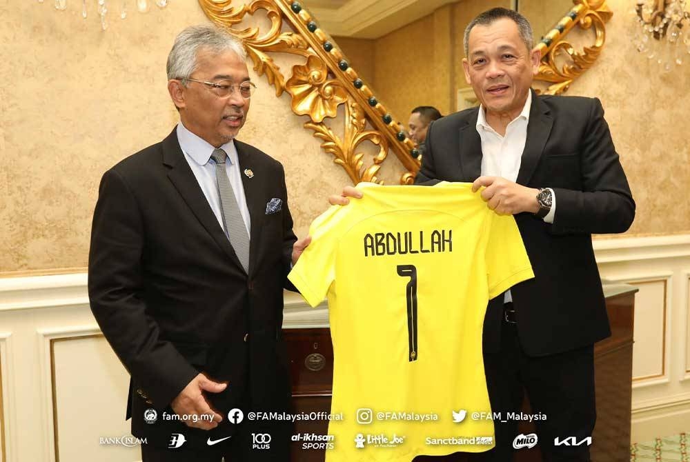 Hamidin mempersembahkan jersi Harimau Malaya baharu berwarna kuning (utama/home) dan hitam (kedua/away) bernombor satu dengan nama ‘Abdullah’ kepada Al-Sultan Abdullah. - Foto FB FAM