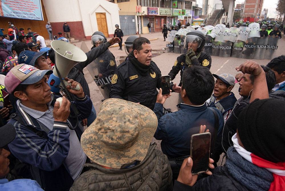 Polis antirusuhan cuba menghalang kemaraan penunjuk perasaan yang mahu menuju ke lapangan terbang di Cuzco. - Foto: AFP