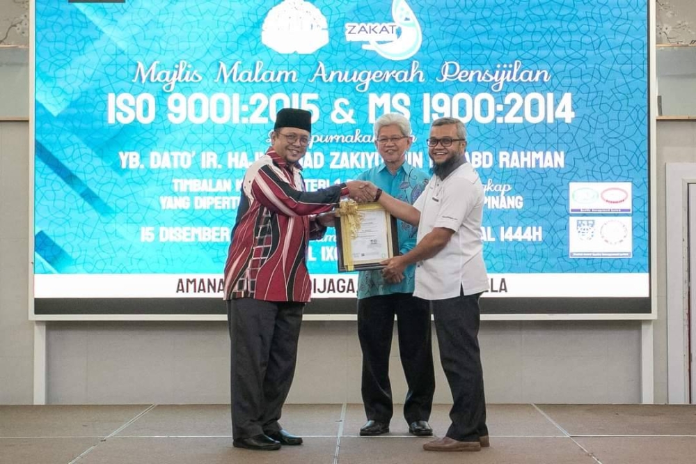 Amran (kiri) menerima Pensijilan ISO 9001:2015 dan MS 1900:2014 dari pihak Platinum Shauffmantz Veritas Sdn Bhd