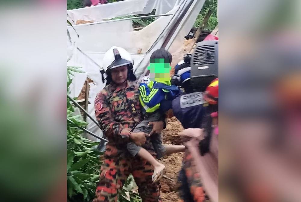 Seorang kanak-kanak dibawa ke tempat lebih selamat oleh anggota bomba.