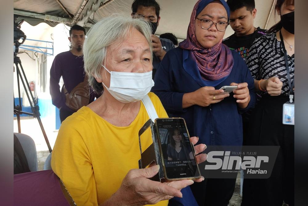 Ah Choe menunjukkan gambar anak perempuannya yang masih hilang dalam kejadian tanah runtuh di Father's Organic Farm, Jalan Genting, Batang Kali pada Jumaat.