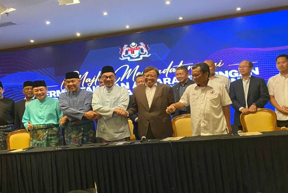 Anwar (tengah) semasa Majlis Menandatangani Permuafakatan Antara Gabungan di Bawah Kerajaan Perpaduan pada Jumaat.