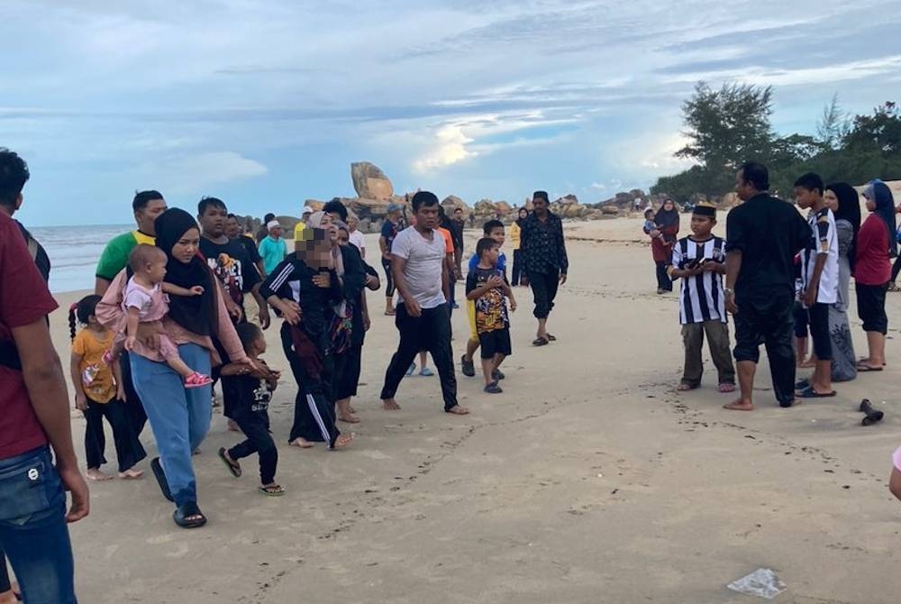 Mangsa yang nyaris lemas di Pantai Penunjuk, Kijal di Kemaman berjaya diselamatkan keluarga dan orang awam yang berkunjung ke pantai itu. - Foto Ihsan pembaca