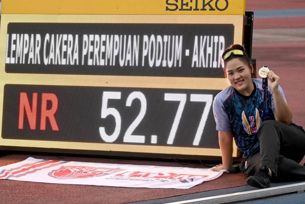 Queenie Ting bersama catatan rekod baharu yang diciptanya dalam acara lempar cakera wanita pada Kejuaraan Olahraga IPT di Stadium Mini MSN, Bukit Jalil pada Jumaat. - Foto: KPT