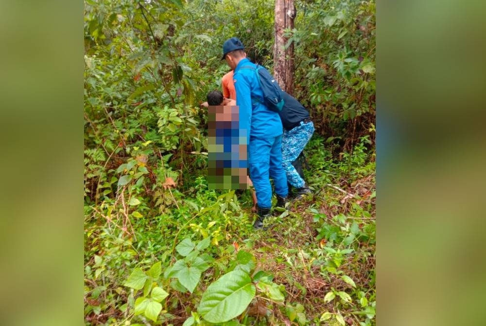 Norhisham (kiri) yang ditemui pasukan SAR ketika usaha mencarinya di hutan di Kuala Krai. - Foto Bomba