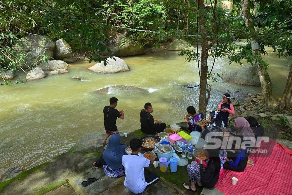 Sebuah keluarga berkhemah di tepi sungai Janda Baik. - FOTO MOHD HALIM ABDUL WAHID