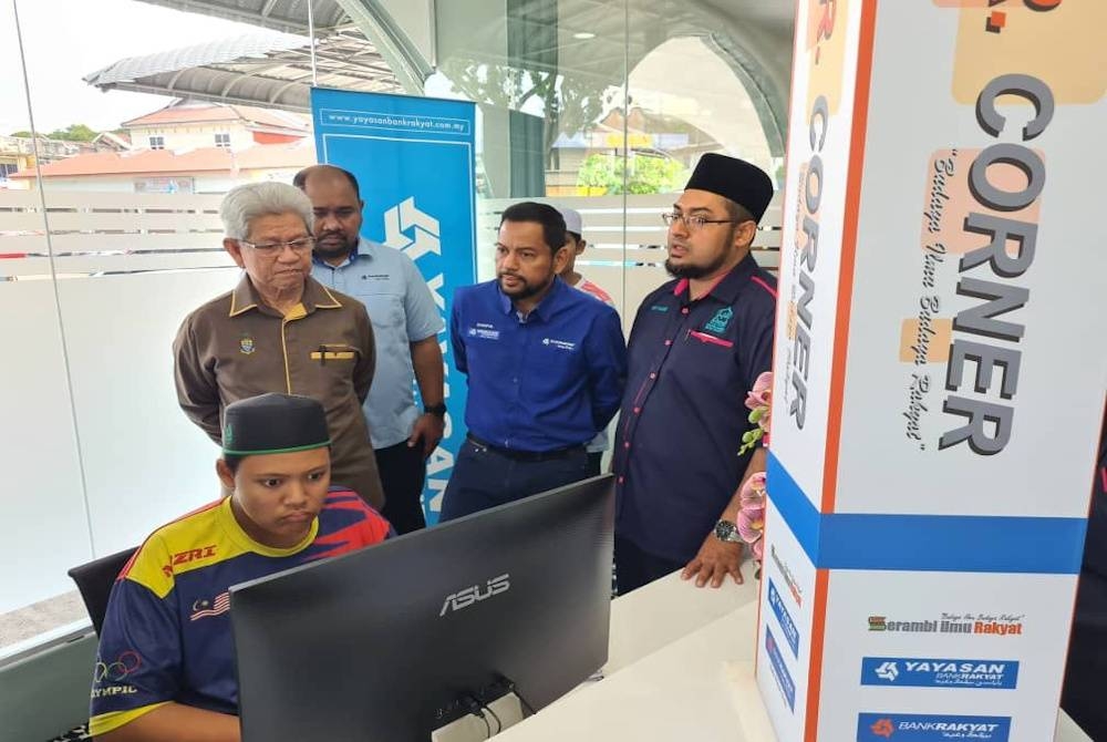 Ahmad Zakiyuddin (berdiri kiri) meninjau perpustakaan digital di Masjid Jamek Shaik Eusoff di Georgetown.