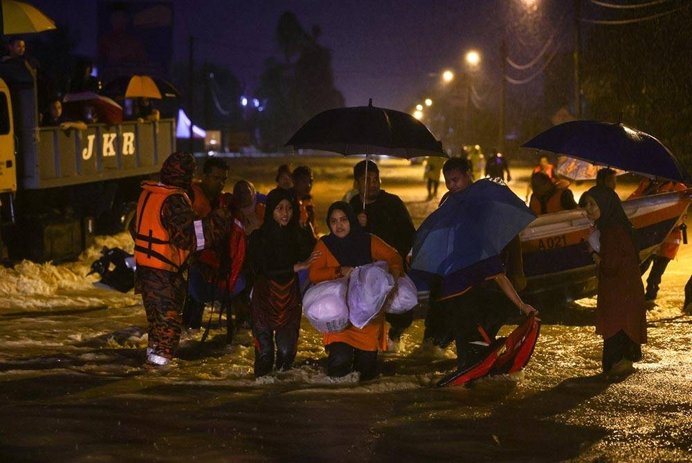 Penduduk setempat di Setiu, Terengganu mula menyelamatkan diri selepas air memasuki rumah mereka semasa tinjauan malam ini. Foto Bernama