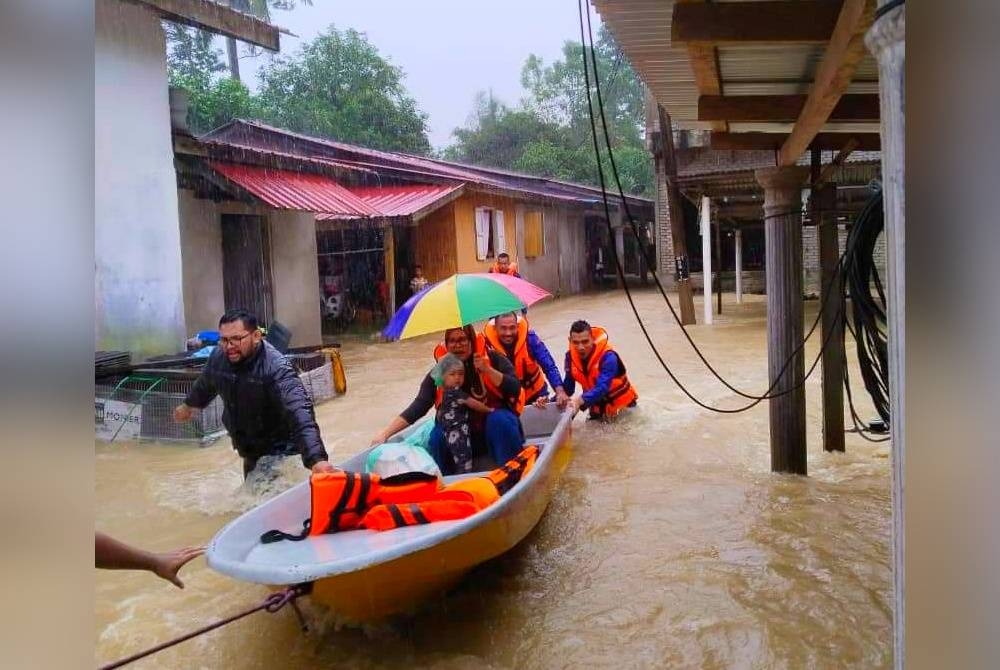 Anggota Angkatan Pertahanan Awam Malaysia (APM) sedang melakukan kerja-kerja menyelamat di Kampung Pulai Chondong, Machang berikutan cuaca buruk di negeri ini. - Foto APM