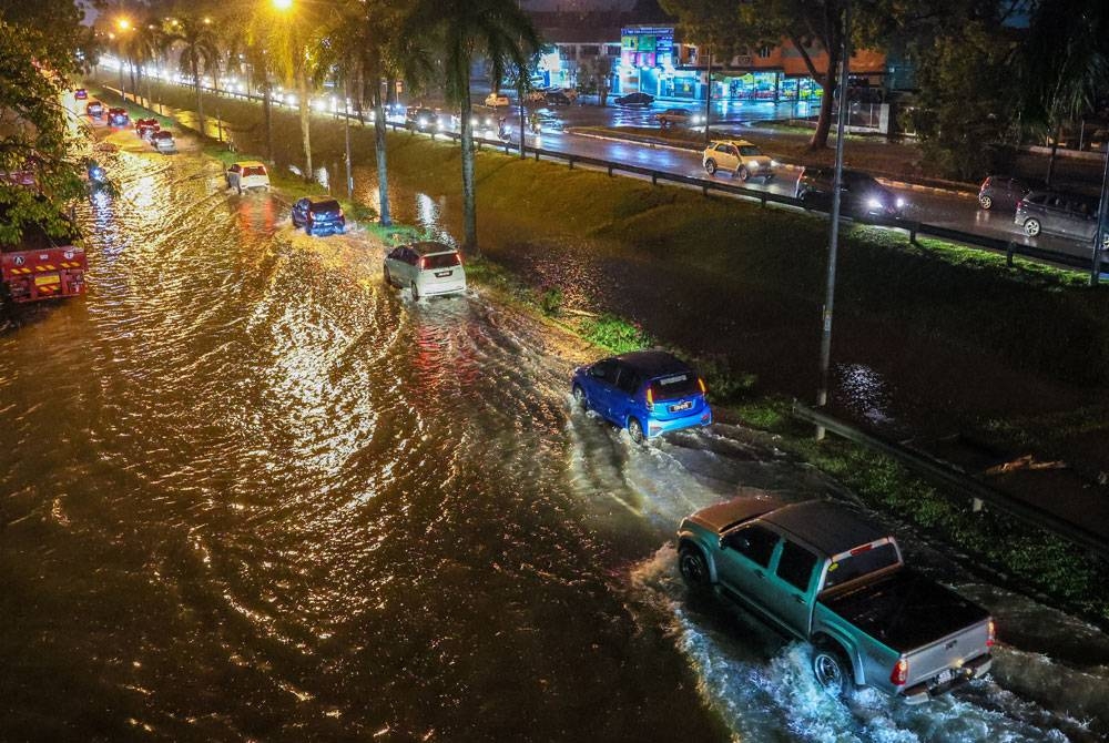 Keadaan Jalan Tanah Putih menghala ke Pusat Bandaraya Kuantan yang ditutup sementara setelah dinaiki air akibat banjir kilat selepas hujan lebat sejak jam 3 petang Ahad. - Foto Bernama