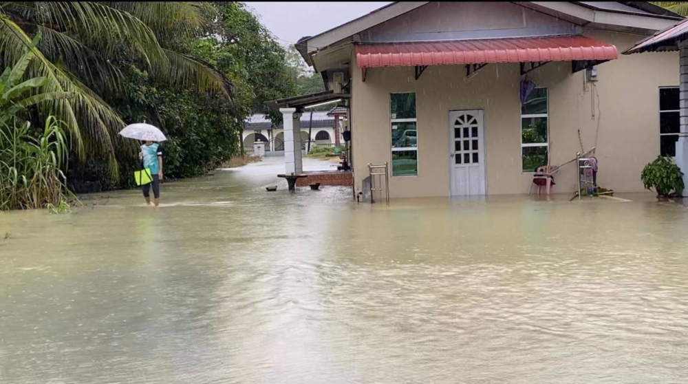 Keadaan rumah penduduk di Kampung Bukit Abal, Pasir Puteh yang mulai dilanda banjir sejak Ahad.