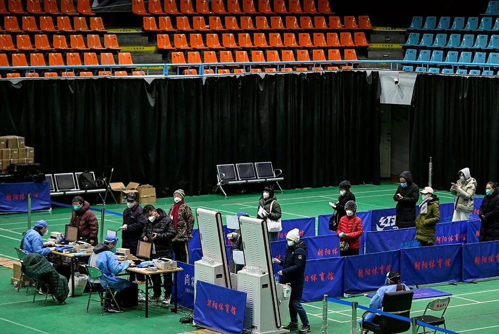 Penduduk menunggu giliran untuk bertemu doktor di klinik sementara yang dibuka di sebuah stadium tertutup di Beijing. -Foto AFP