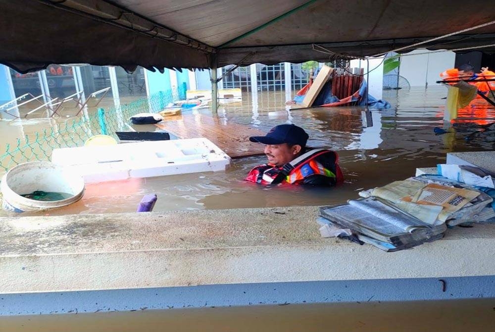 Salah seorang anggota APM Pasir Mas sanggup meredah banjir demi operasi menyelamat.