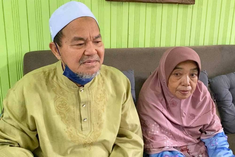 Mohd Nadzir (kiri) dan isteri terpaksa melawan perasaan sedih atas pemergian tiga anak mereka pada Isnin.