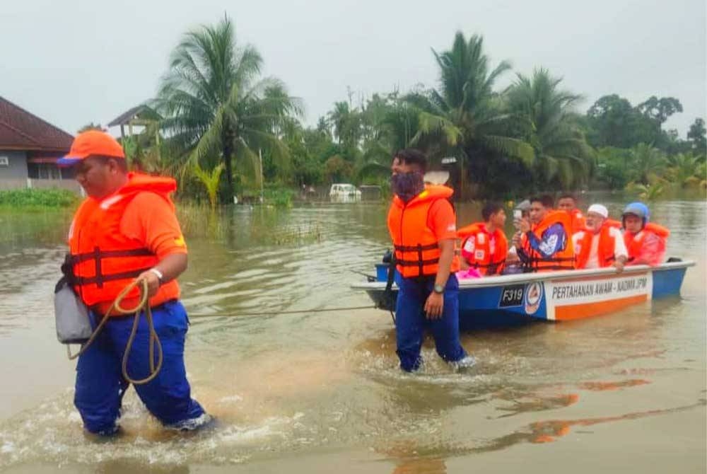 AnggotaAPM melakukan kerja-kerja menyelamat mangsa banjir di Kampung Jejulok, Banggu, Kota Bharu pada Selasa.