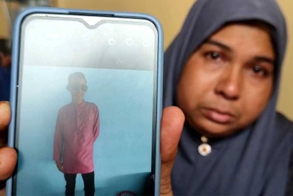 Safinah menunjukkan gambar anak bongsunya, Muhammad Izani Mohd Tuah yang terlibat dalam kemalangan maut di Sungai Petani pada awal pagi Selasa.