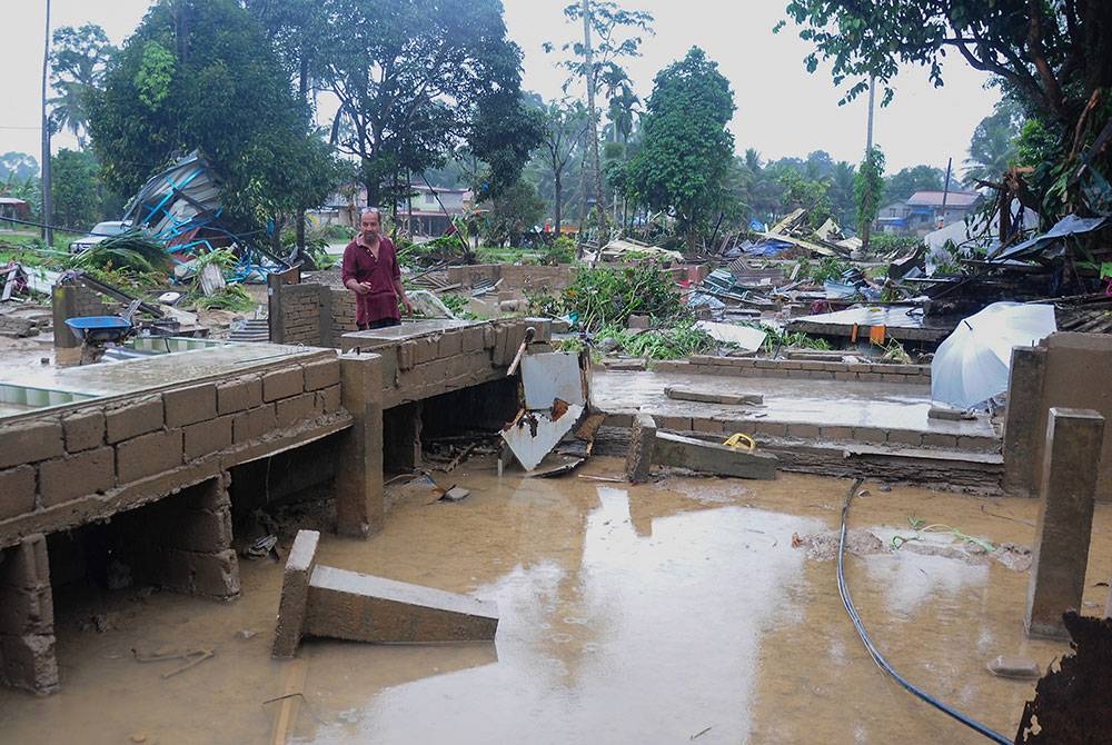 Raja Kamaruddin sayu melihat rumahnya yang dihanyutkan arus deras dalam kejadian banjir besar di Kampung La, Hulu Besut jam 3 pagi pada Isnin. - Foto: Bernama