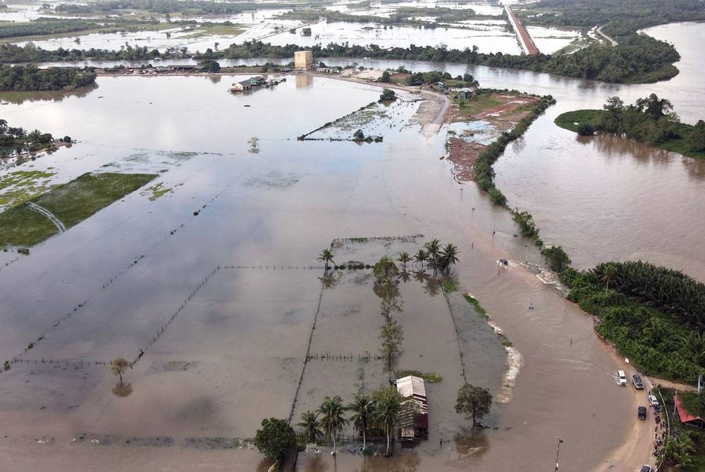 Limpahan air Sungai Golok yang mula memenuhi Jalan Pengkalan Kubor ke Kampung Simpangan di Tumpat ketika tinjauan pada Rabu. - Foto: Bernama