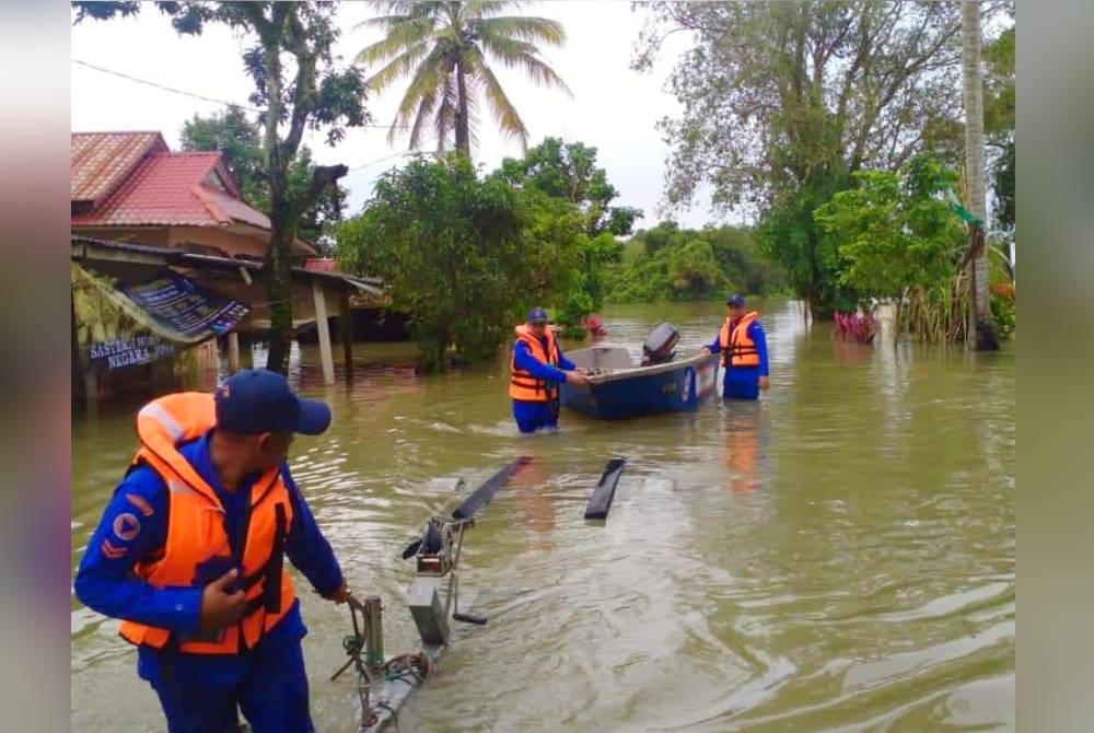 Anggota APM bersiap sedia memasuki kawasan kampung bagi menjalankan misi menyelamat apabila air banjir mulai melimpah di Tumpat.