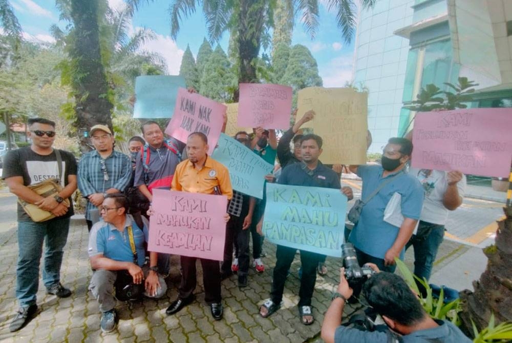 Kamarul (lima kiri) dan kumpulan pekerja yang hadir turut mengadakan perhimpunan secara aman bagi menuntut syarikat membayar gaji tertunggak dan pampasan.