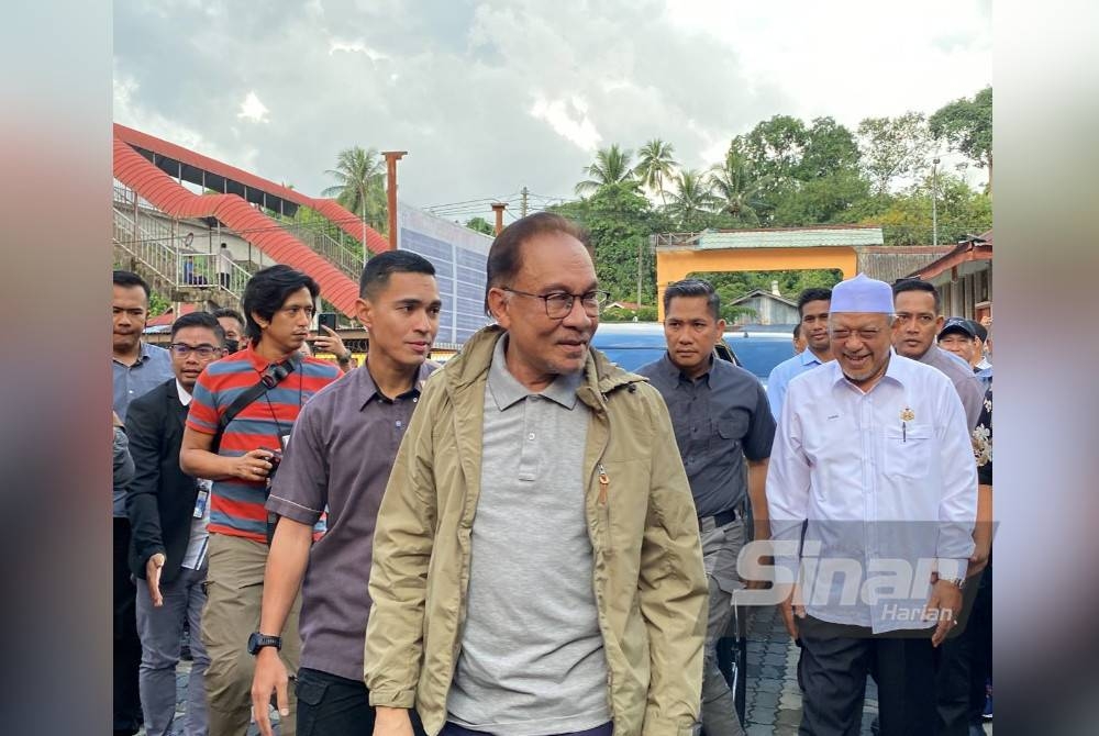 Anwar (hadapan) bersama Menteri Besar Kelantan, Datuk Ahmad Yakob (kanan) semasa hadir di PPS SMK Tengku Panglima Raja, Pasir Mas pada Rabu.