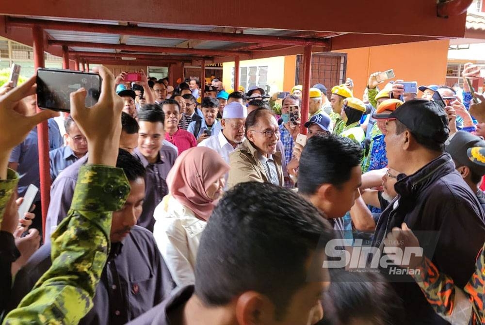 Anwar disambut meriah oleh mangsa banjir di PPS SMK Tengku Panglima Raja, Pasir Mas pada Rabu.