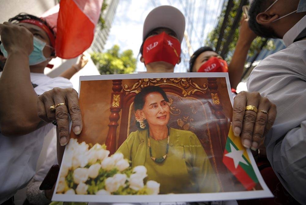 Seorang pekerja migran Myanmar yang tinggal di Thailand memegang gambar Suu Kyi pada perhimpunan di luar kedutaan Myanmar di Bangkok, Thailand pada Isnin. - Foto EPA