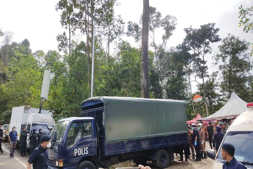 Trak polis bersedia untuk membawa mayat mangsa yang ditemui pada Khamis.