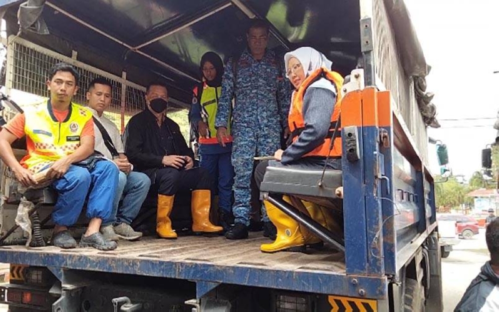 Dr Zaliha (kanan) menaiki lori ke PPS Gual Periuk, Rantau Panjang yang menempatkan lebih 1,000 mangsa banjir.