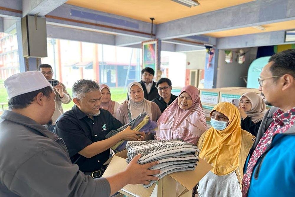 Antara mangsa banjir yang menerima sumbangan di PPS SK Kemasik.