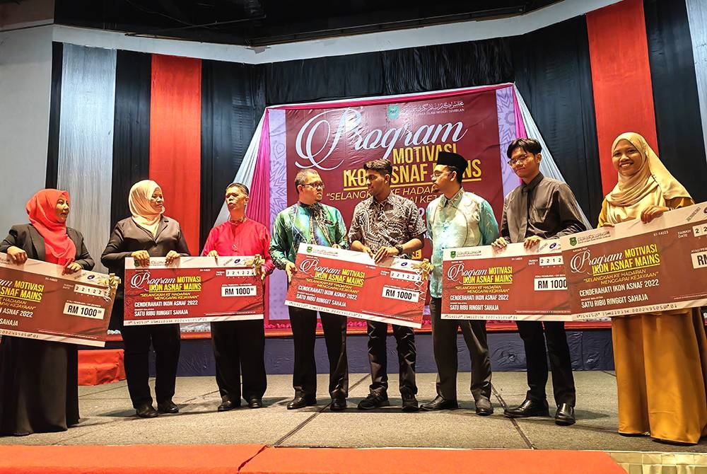 Zainal (empat dari kiri) beramah mesra dengan penerima anugerah Ikon Asnaf. Turut kelihatan Siti Aidah (dua dari kiri) dan Rohaidah (kiri)