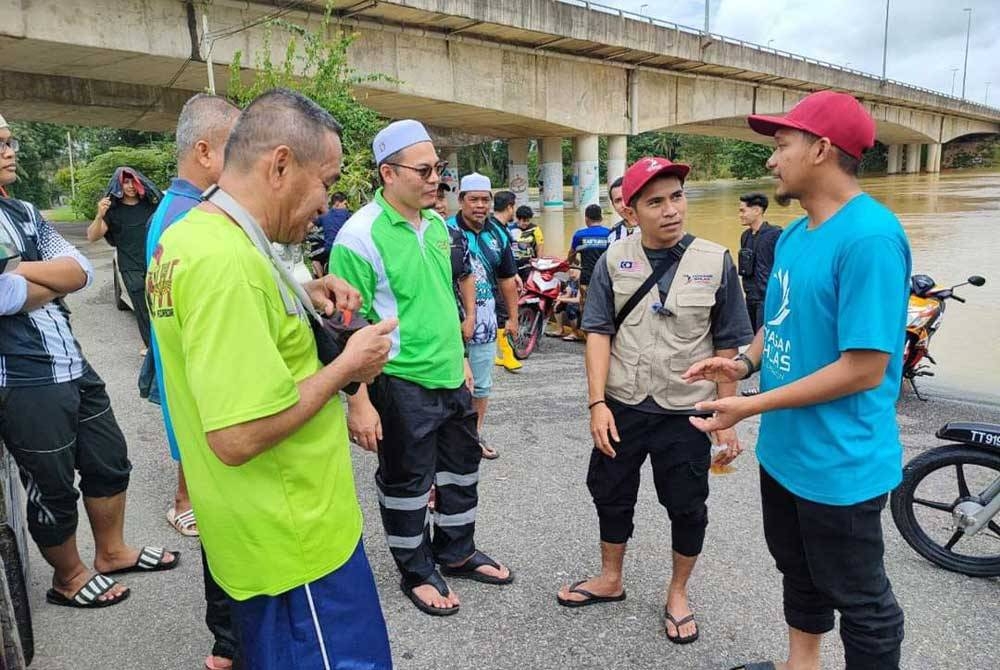 Hishamuddin (tiga dari kanan) bersama Bell Ngasri (dua dari kanan) ketika misi bantuan banjir di kawasan Tepoh. - Foto ihsan Facebook Hishamuddin Abdul Karim