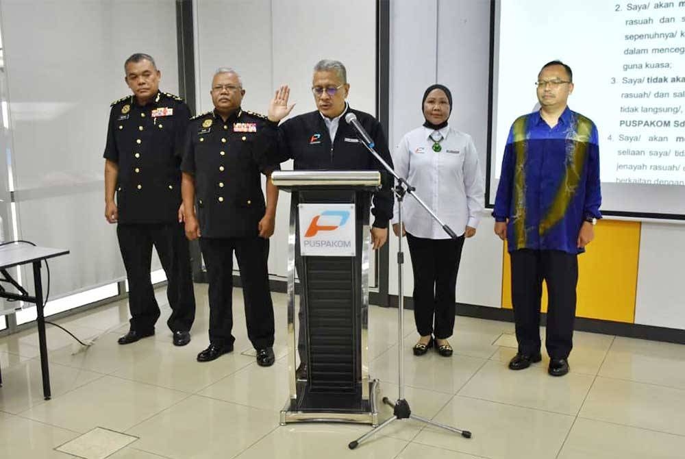 Mohammed Shukor (tengah) mengetuai warga PUSPAKOM melafazkan IBR, disaksikan oleh (dari kiri) Ridzuan, Alias, Samsiah dan Hashim di ibu pejabat PUSPAKOM di Shah Alam, Selangor.