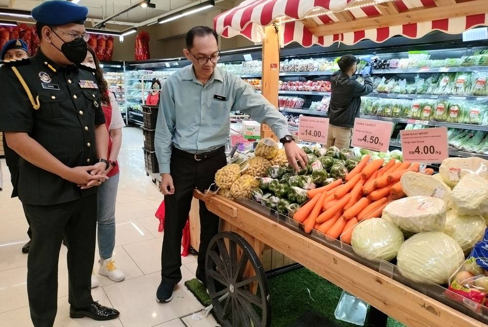 Mark (kanan) bersama Ketua Pegawai Penguat kuasa KPDN Pahang, Muhamad Radzi Johari meninjau barangan yang diwartakan sempena SHMMP Krismas di sebuah pasar raya pada Jumaat.