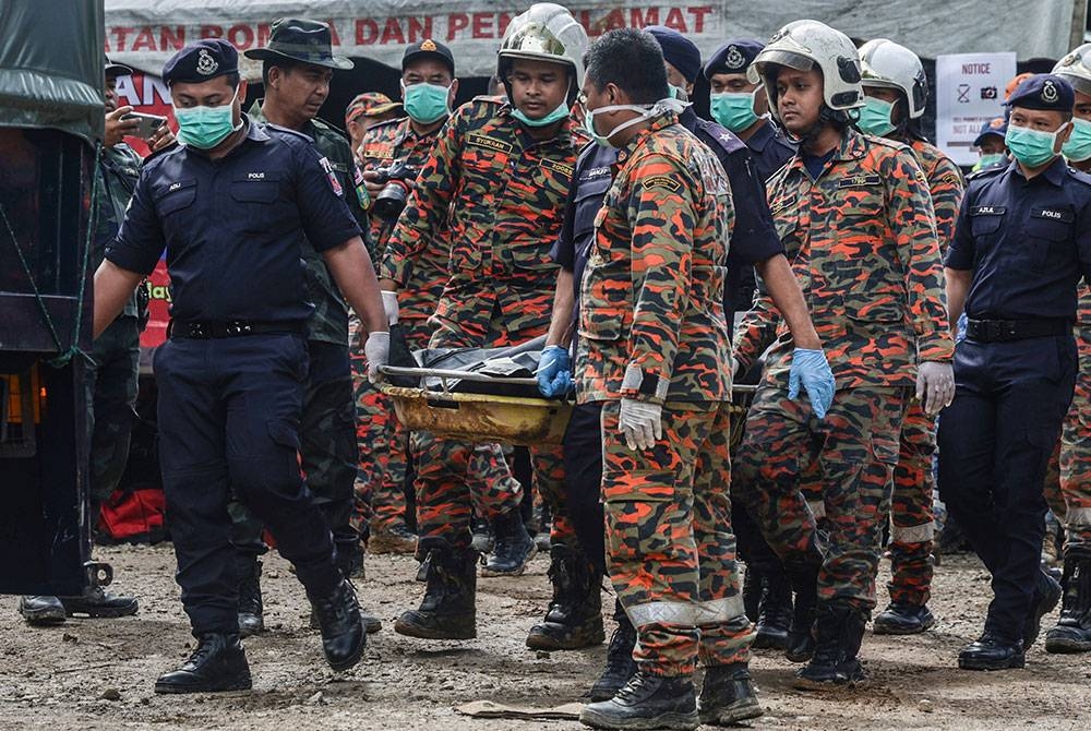 Anggota operasi SAR mengangkat mayat mangsa yang ditemui dalam tragedi tanah runtuh di tapak perkhemahan Fathers’ Organic Farm, Batang Kali.