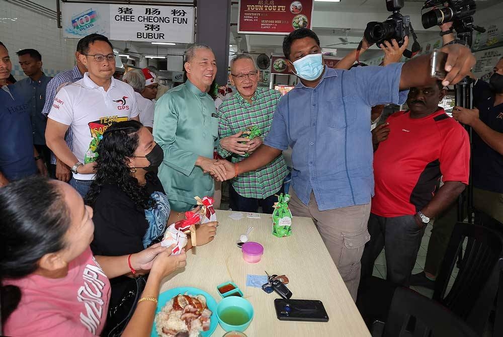 Fadillah (tiga dari kiri) berswafoto dengan pengunjung restoran ketika majlis Christmas Give Away sempena sambutan perayaan Krismas pada Sabtu. - Foto Bernama