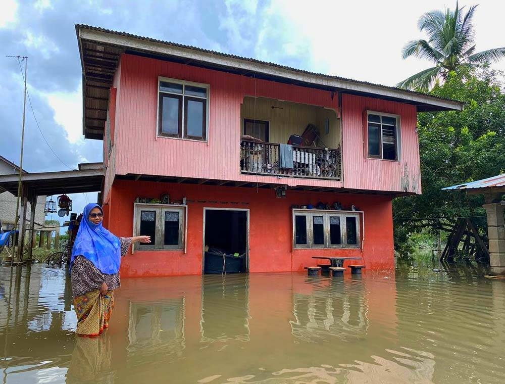 Mariam menunjukkan keadaan banjir di rumahnya di Kampung Banggol Kong, Pasir Mas yang semakin surut selepas hampir seminggu dinaiki air.