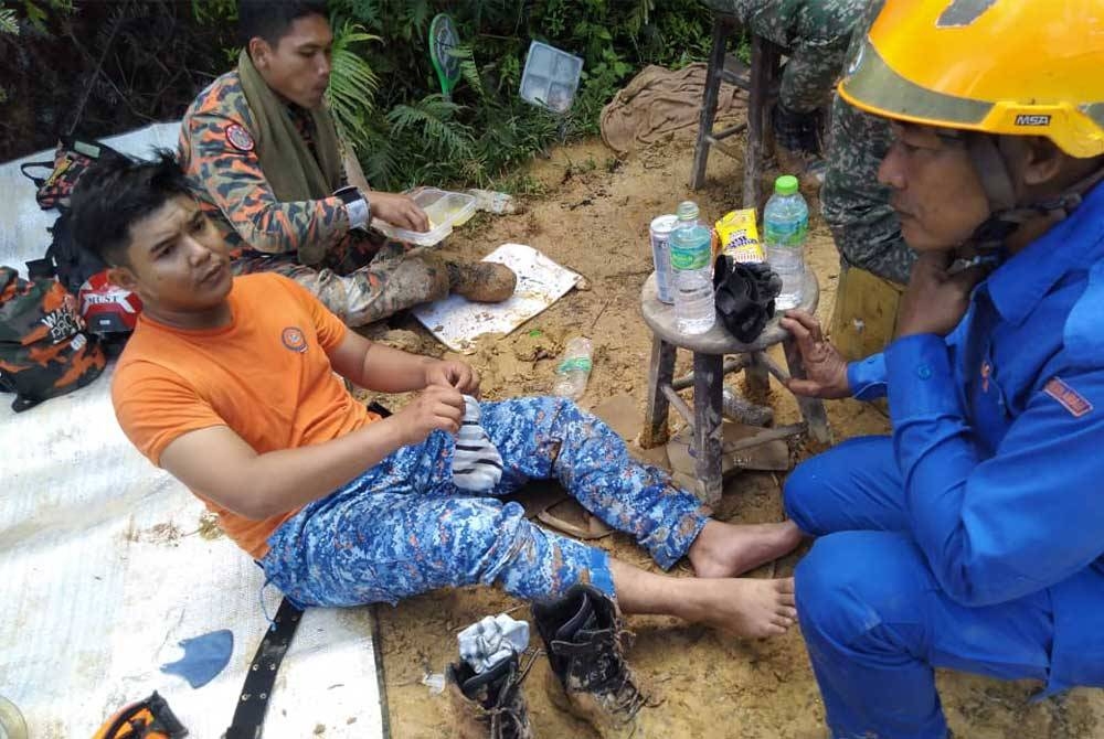 Muhammad Faiq(kiri) ketika mendapatkan rawatan awal setelah pengsan ketika menjalankan operasi SAR mangsa tragedi tanah runtuh di tapak perkhemahan di Father&#039;s Organic Farm, Jalan Genting-Batang Kali di sini pada 24 Disember lalu.