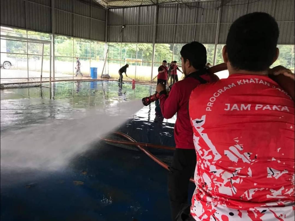 Pasukan Amal ketika membantu membersihkan tempat yang terjejas banjir. - Foto Jabatan Amal