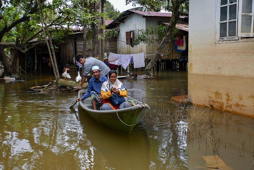 Sebahagian penduduk masih menggunakan bot untuk ke jalan utama berikutan kawasan kediaman mereka masih digenangi banjir walaupun air mulai surut ketika tinjauan di Kampung Tersang, Rantau Panjang pada Isnin. - Foto Bernama