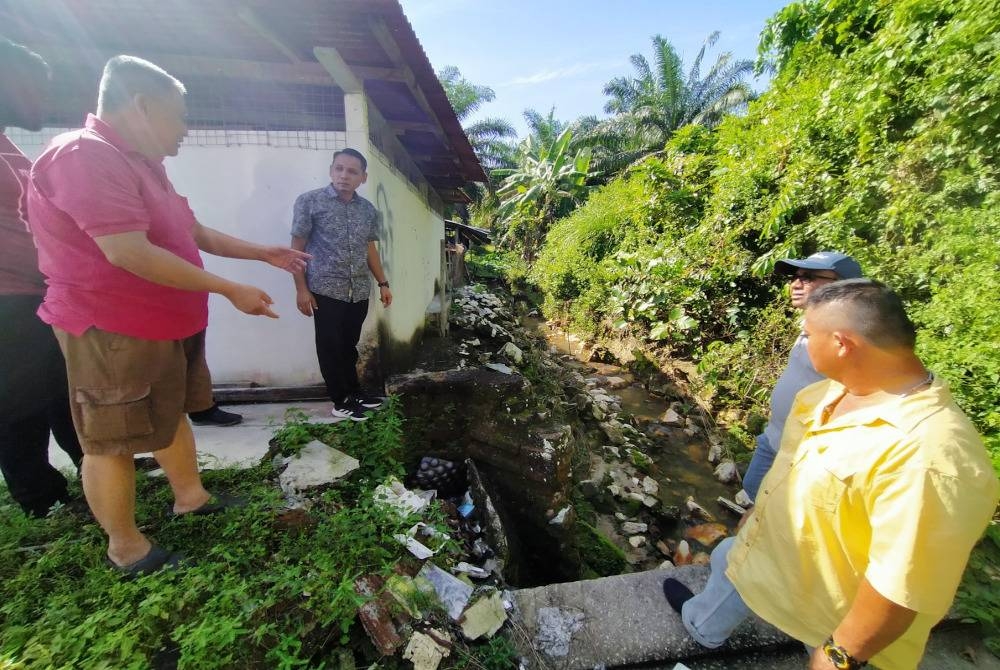 Mohd Azlan Helmi (dua dari kiri) mendengar luahan Kam Fook (kiri) mengenai keadaan longkang yang mengakibatkan banjir kilat sering berlaku di kawasan tersebut.