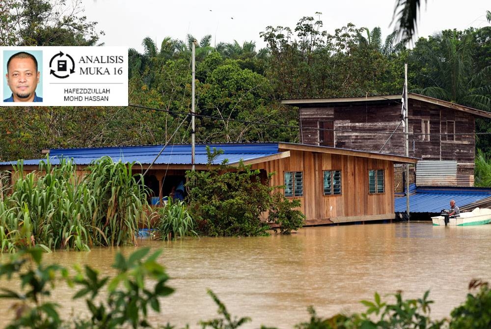 Mangsa banjir A Bakar memantau keadaan di sekitar rumahnya menggunakan bot disebabkan beliau sekeluarga tidak berpindah ke pusat pemindahan sementara (PPS) kerana tinggal di rumah terapung yang dibinanya sendiri di Kampung Terbak Batu 16 Chukai, baru-baru ini. - Foto Bernama