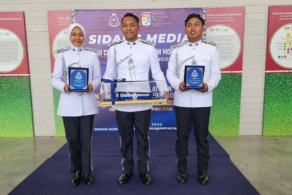 Muhammad Azhar (tengah) selepas menerima anugerah pelatih terbaik Kor Suksis UKM 2022.