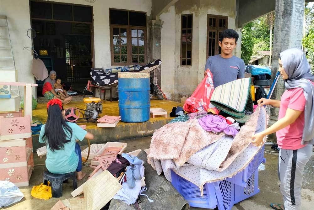 Penduduk di Kampung Serongga, Rantau Panjang sedang giat mencuci selepas kediaman mereka dilanda banjir.