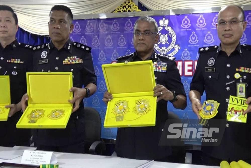 Ramli (dua dari kanan) menunjukkan pingat darjah kebesaran yang membawa gelaran Datuk dan Datuk Seri yang dirampas oleh pihak polis dalam sidang akhbar di Bilik Anggerik, Ibu Pejabat Polis Daerah Kuantan pada Selasa.