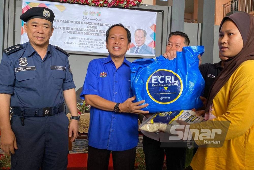 Ahmad (dua dari kiri) menyampaikan sumbangan kepada mangsa banjir pada Program Penyampaian Bantuan Bencana Banjir di Pejabat Tanah dan Jajahan Machang pada Selasa.