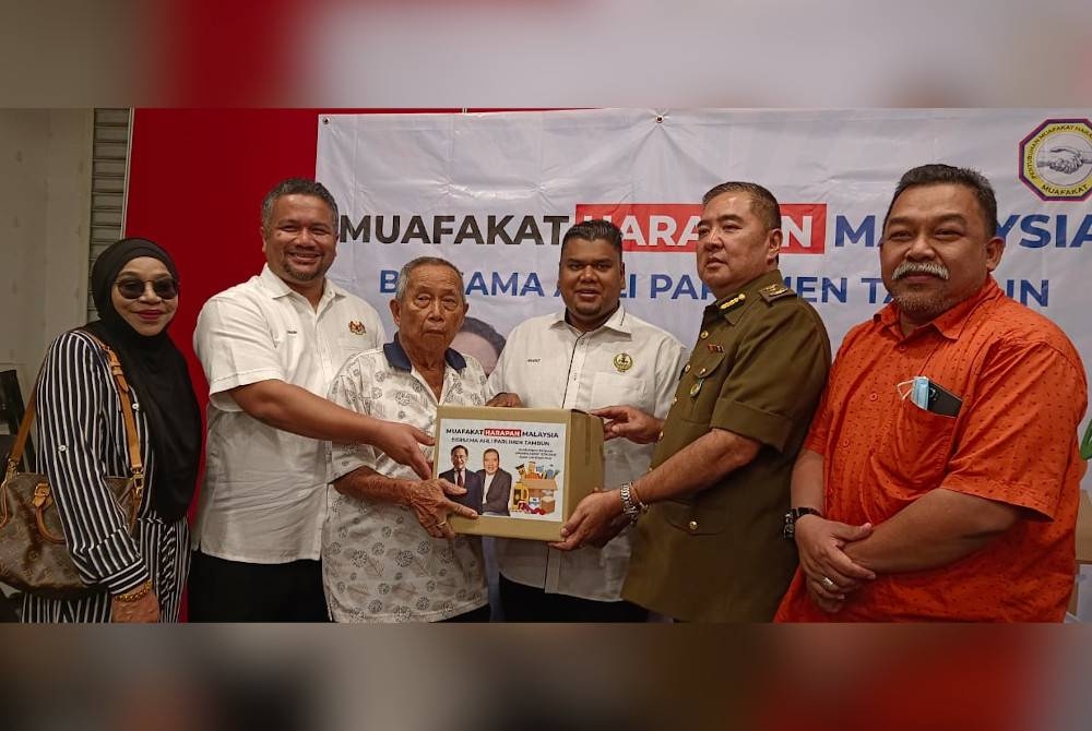 Muhamad Arafat (tiga dari kanan) menyerahkan pek makanan yang disumbangkan Muafakat kepada penduduk yang memerlukan.