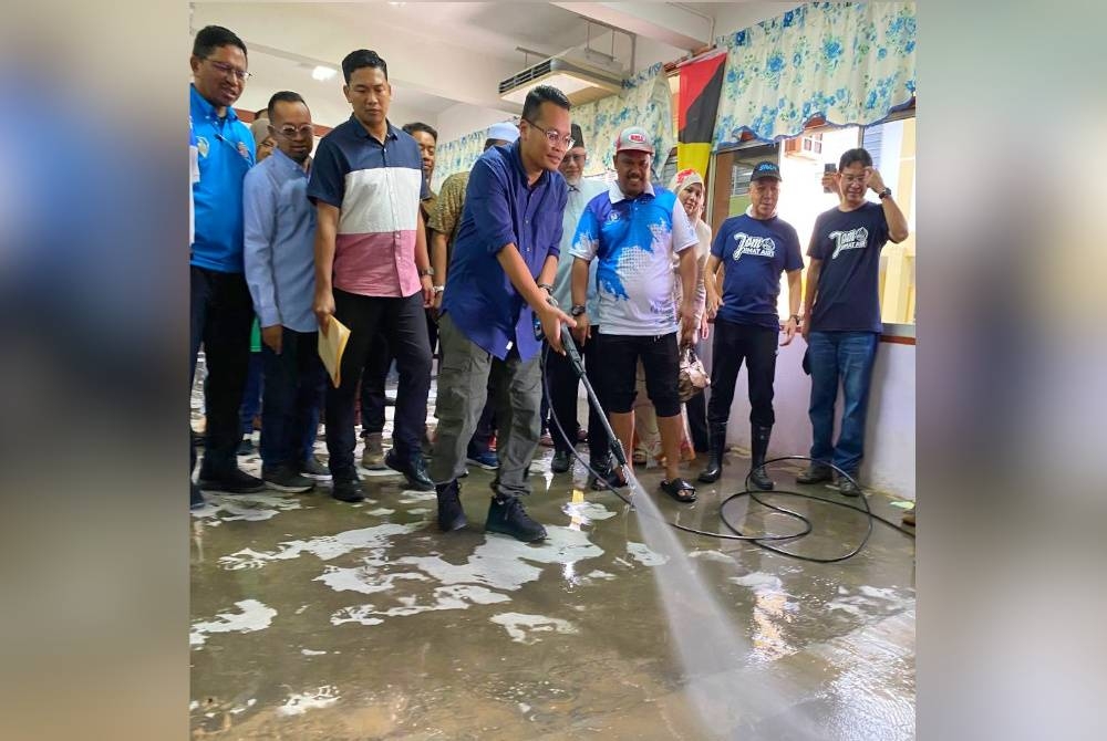 Nik Nazmi turut sama melakukan kerja mencuci ketika Program Gerak Kerja Pasca Banjir di SK Bendang Pa' Yong, Tumpat pada Khamis.