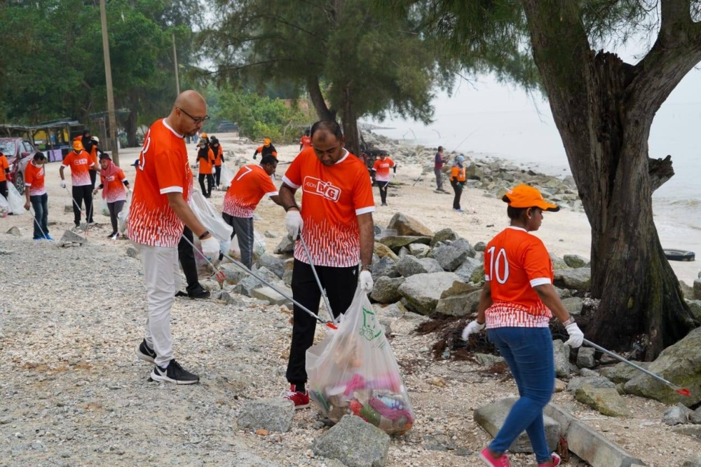 Sebahagian kakitangan AEON BiG yang menyertai aktiviti gotong-royong mengutip sampah di Pantai Remis.