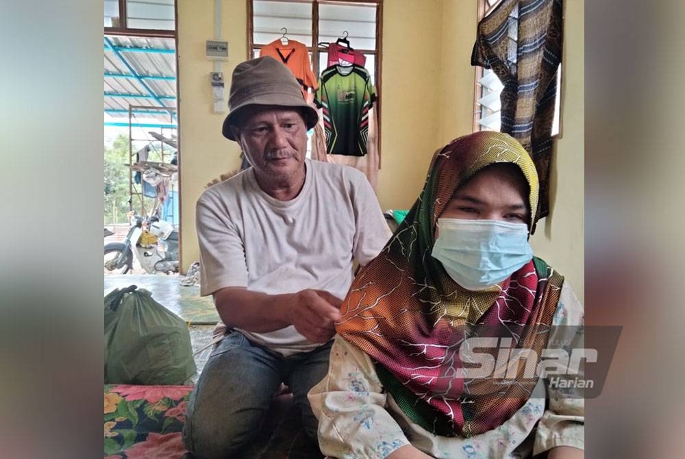 Zulkefli membetulkan tudung Siti Rohajar yang buta kedua-dua belah mata akibat komplikasi jantung dan buah pinggang.